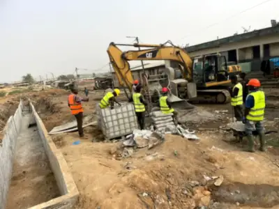Pelle mécanique et équipe sur le chantier de caniveaux d’Anyama Gare